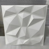 White PVC 3D wall panel, 50 x 50cm, with irregular pyramid facets in a geometric grid, shown upright against a plain light background.