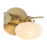 Addie 2 Light G9 Wall Light in antique brass with an oval opal glass shade illuminated, set on a plain white background.