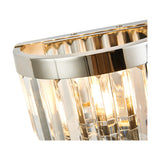 Close-up of the Cosette 2 Light E14 Wall Light in polished nickel, showing clear K9 crystal rods and curved metal frame with visible lamp glow, on a plain white background.