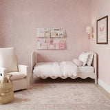 Dancer Convertible Cot Bed in cashmere with scalloped base edge and white bedding, shown as a toddler bed in a pink nursery setting.