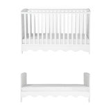 Dancer Convertible Cot Bed in white MDF with slatted sides and scalloped base, shown above as a toddler bed with matching headboard and footboard, on a plain white background.