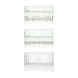 Dancer Convertible Cot Bed in white MDF, shown at three base height positions with slatted sides and scalloped bottom edge, on a plain white background.