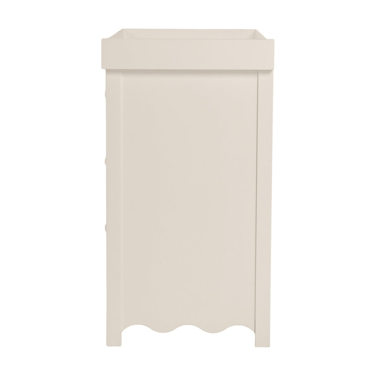Side view of the Dancer changing table in cashmere, MDF cabinet with raised tray top, scalloped base edge, and metal drawer runners visible, on a plain white background.