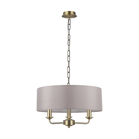 Banyan 3 Light E14 pendant with a grey 45cm fabric drum shade, antique brass ceiling rose, chain, and three candle arms, shown on a plain white background.