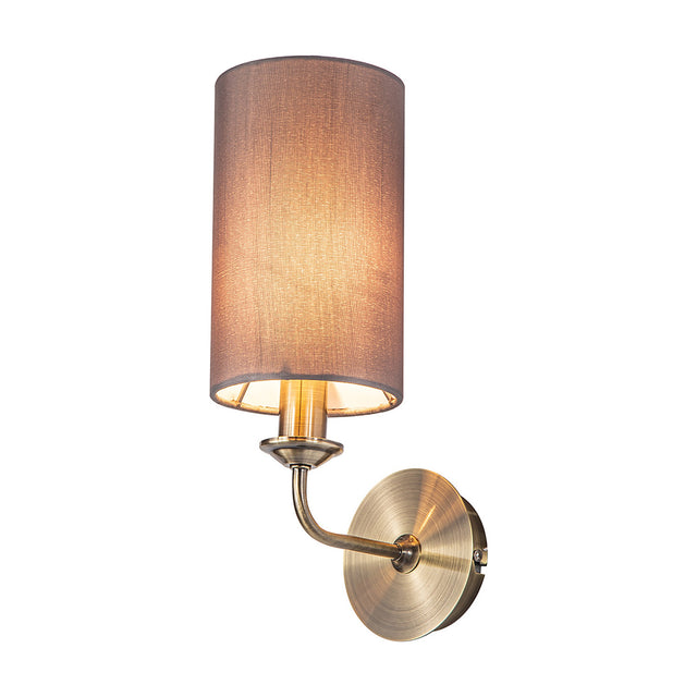 Banyan E14 wall light, 35.5cm high, with a cylindrical grey fabric shade on a slim antique brass arm and round wall-mounted base, shown against a plain white background.