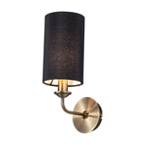 Banyan E14 wall light, 35.5cm high, in antique brass with a cylindrical black fabric shade and curved arm, shown on a plain white background.