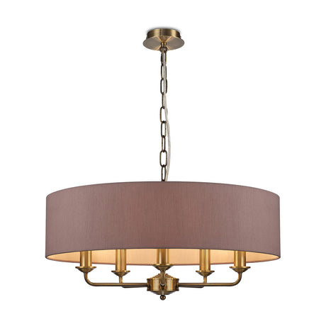 Banyan 5 Light E14 Pendant Light with taupe faux silk drum shade, 60cm wide, antique brass frame and candle-style arms, hung from a chain, on a plain white background.