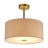Baymont semi-flush ceiling light with a 40cm beige faux silk drum shade, antique brass frame and stem, and frosted acrylic diffuser, shown lit on a white background.