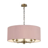 Banyan 5-light E14 pendant in antique brass with curved candle arms beneath a 60cm taupe drum shade with gold lining, chain suspension, shown on a white background.