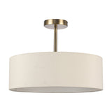 Baymont 3 Light Semi Flush ceiling light with a shallow ivory drum fabric shade on an antique brass ceiling rod and mount, shown on a plain white background.