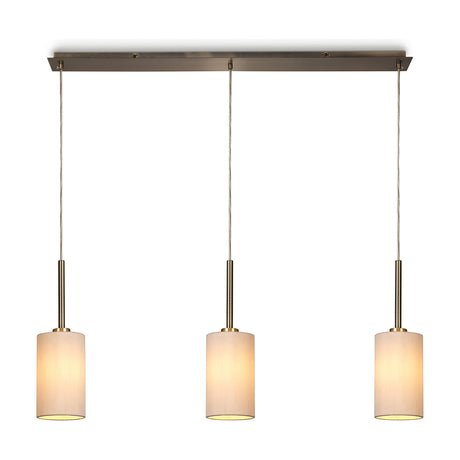 Baymont 3-light pendant with antique brass bar and cable suspensions, nude beige fabric drum shades, on a plain white background.