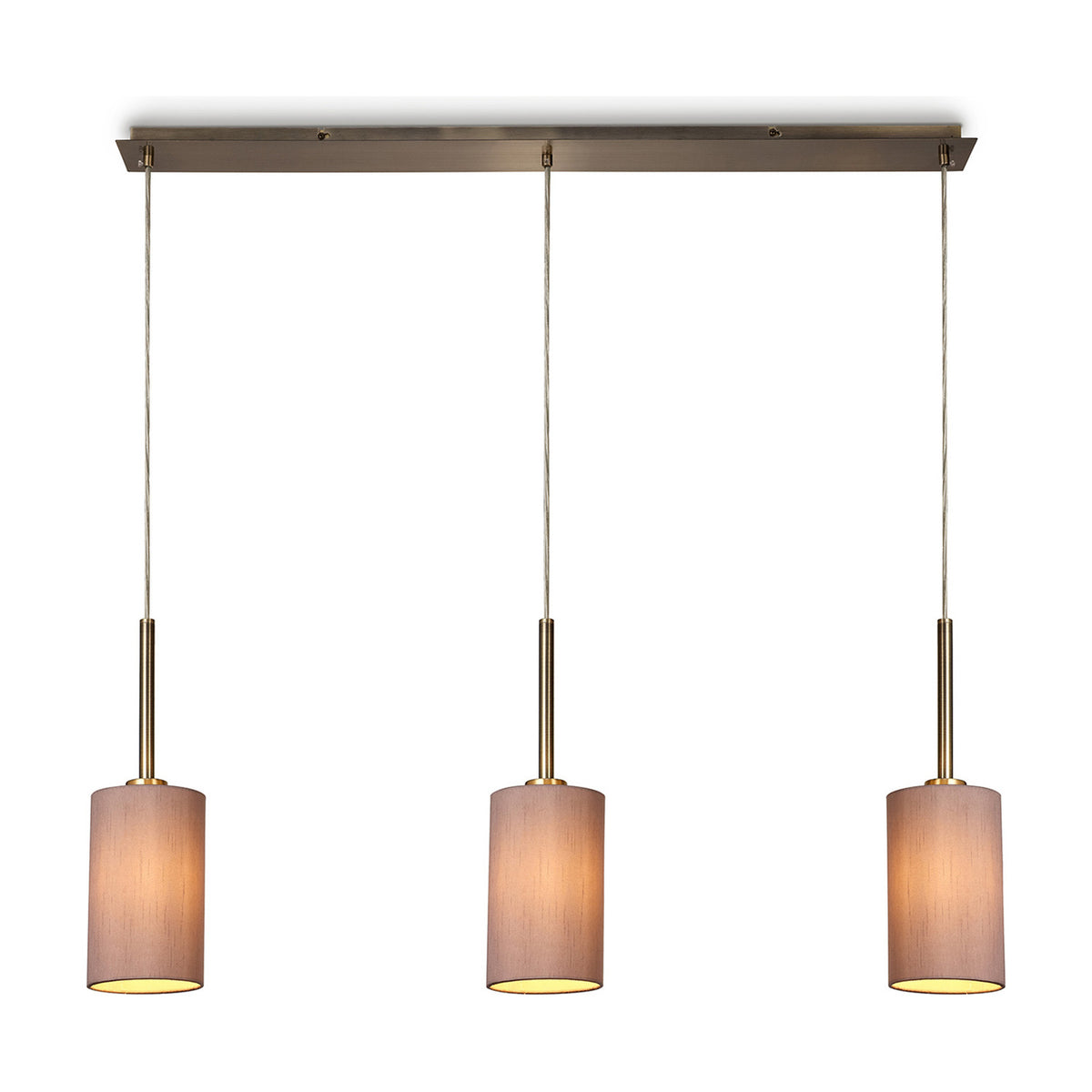 Baymont 3 Light Pendant Light with slim antique brass bar and three taupe fabric drum shades on cords, shown lit against a plain white background.