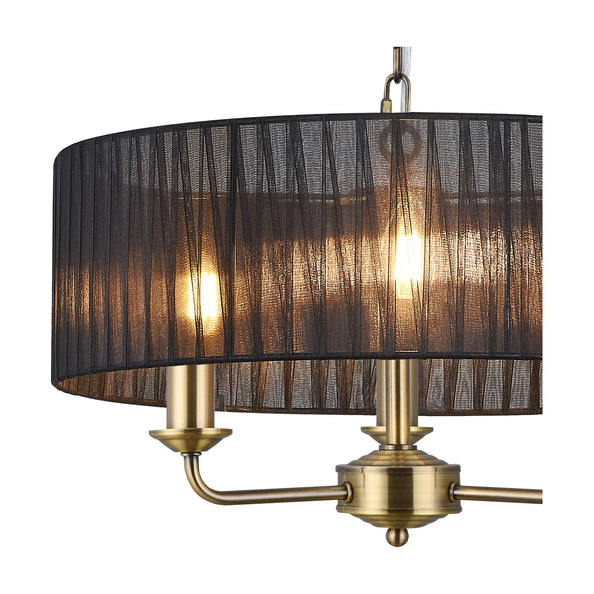Close-up of the Banyan 3 Light E14 Pendant Light in antique brass, showing candle-style arms lit beneath a black organza shade with visible fine weave, on a white background.