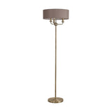 Banyan 3 Light E14 floor lamp with a slim antique brass column, three candle lights, and a 45cm grey faux silk drum shade, shown on a round brass base against a plain white background.