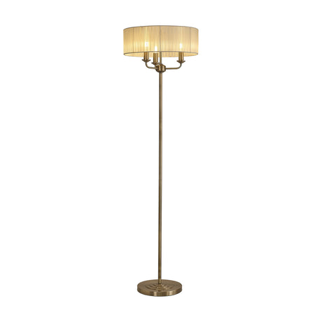 Banyan 3 Light E14 floor lamp with a 45cm cream fabric drum shade over three candle lights, slim antique brass column, and round base, on a plain white background.