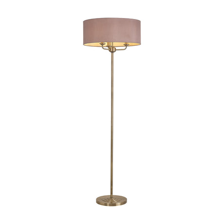 Banyan 3 Light E14 floor lamp with a wide taupe drum shade on a slender antique brass column and round base, shown on a plain white background.