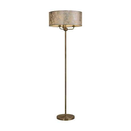 Banyan 3 Light E14 Floor Lamp with a wide drum shade in silver foil finish atop a slim antique brass column and round base, shown on a plain white background.