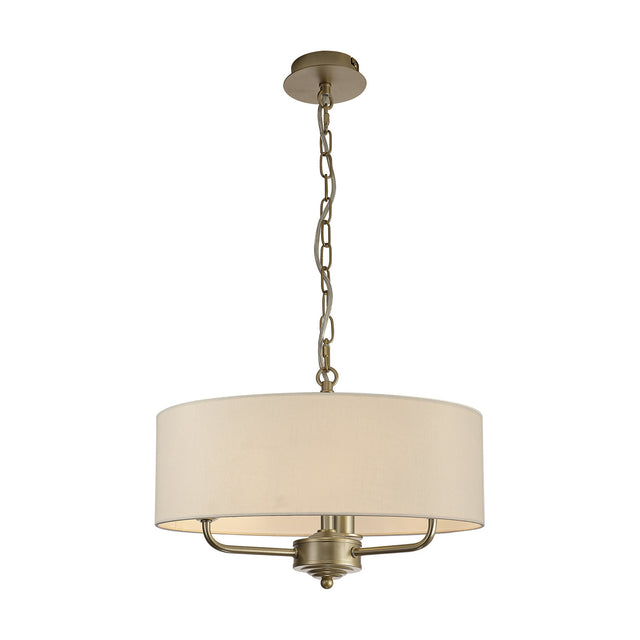 Banyan 3 Light Pendant Light in champagne gold with an ivory pearl fabric drum shade, hung from a chain link, shown on a plain white background.