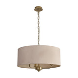 Banyan 3 Light E14 pendant light with a wide nude beige drum shade on a champagne gold frame and chain, three candle arms hidden inside, shown on a plain white background.