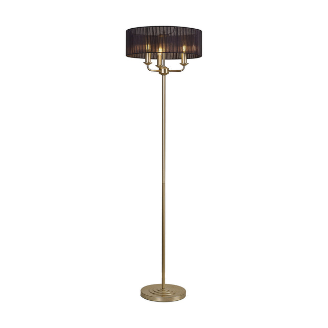 Banyan 3 Light E14 floor lamp with a wide black organza drum shade on a slim champagne gold stand, three candle-style bulbs visible, round base, set on a plain white background.