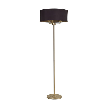 Banyan 3-light floor lamp with a wide 50cm midnight black and champagne gold drum shade, three candle lights beneath, on a slender champagne gold stem with round base.