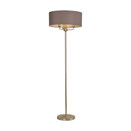 Banyan floor lamp with a wide grey drum shade on a slender champagne gold stem and round base, holding three E14 candle lamps, shown on a plain white background.