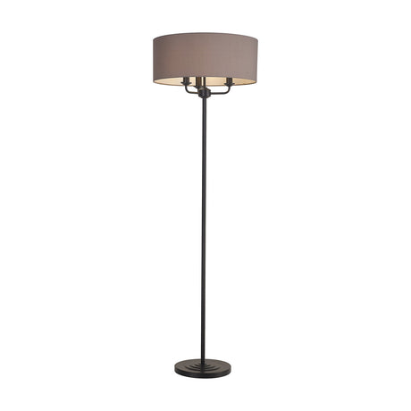 Banyan floor lamp with matt black stem and base, holding a wide grey drum shade over three candle lights, shown on a plain white background.