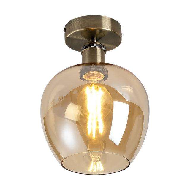 Semi-flush ceiling light with a rounded 18cm amber glass shade and antique brass ceiling plate, fitted with a visible E27 bulb, shown on a white background.