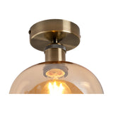 Close-up of the E27 Ceiling Light 18cm in Amber, showing the antique brass ceiling plate, knurled ring detail, and amber glass globe shade with visible bulb.