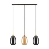 Lori 3 Light Pendant with three oval glass shades in smoke, amber, and smoke, suspended from a slim antique gold bar on black cables against a white background.