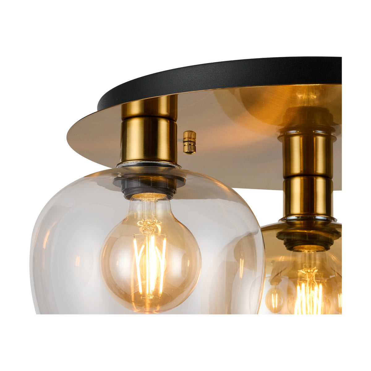 Close-up of the Lori 3 Light Flush Light showing antique gold fittings and clear glass globe shades with visible filament bulbs against a white background.