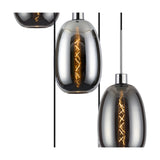 Close-up of the Lori 5 Light Pendant, showing elongated chrome and smoke glass shades with visible filament bulbs and polished chrome cable fittings against a white background.
