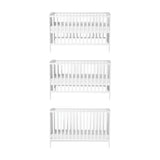 Dreamer Convertible Cot Bed in white MDF, shown at three base height positions with slatted sides and teething rails, on a plain white background.