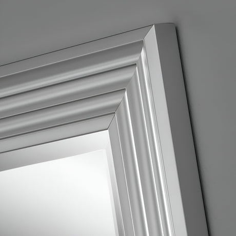 Close-up of the Deco Rectangle Wall Mirror in Matt Silver, showcasing its elegant angled frame with layered and beveled detailing. Set against a gray background, this sophisticated design offers a truly modern look.