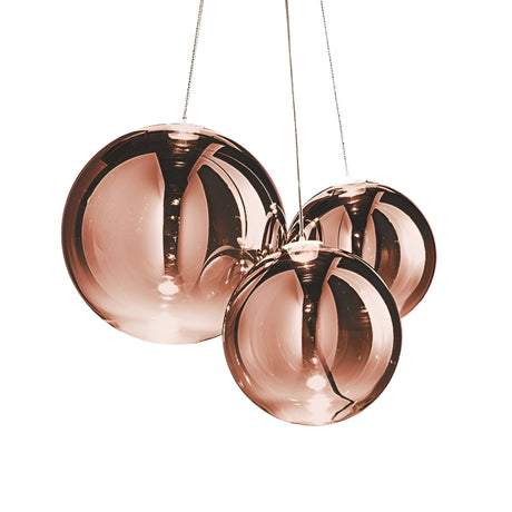 Three Diverso LED Pendant Lights in copper, featuring spherical shapes and reflective surfaces, hang closely together against a white background.