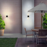 Aura 2 light exterior wall light in black finish, shown in a garden setting