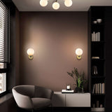 Lunar wall light in black and brass finish, shown in a room setting