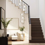 Trapeze 7 light pendant light in brass finish, shown in a room setting