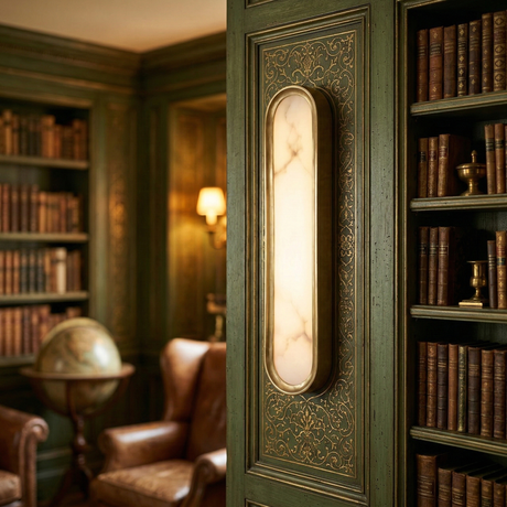Elegant library with green paneled walls, shelves of old books, a marble sconce, the Aurex LED Vertical Alabaster Wall Light in soft white & brushed brass, globe, and leather armchairs—creating a warm, vintage atmosphere.