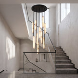 Selvara 10 Light Alabaster Cluster Chandelier in Matt Black, staggered vertical alabaster bars suspended from a round black canopy above a marble staircase.