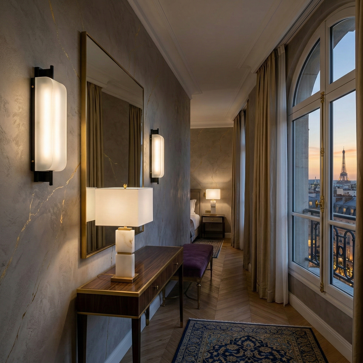 Elegant hotel room with a desk, mirror, Veradex 1 Light Alabaster Block Table Lamp in brass & soft white, large windows, beige curtains, and a sunset view of Paris featuring the Eiffel Tower in the distance.