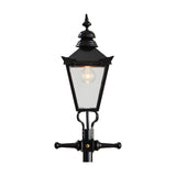 Victorian-style black cast iron lamp post with tapered four-sided lantern head, stepped crown, corner tips, cast finial and cross-arm bracket, shown against a plain white background.