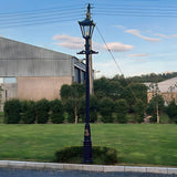 Victorian Cast Iron Lamp Post in black, 3.31m tall with a tapered four-sided lantern head and cast finial, installed on a lawn edged by hedges and trees.