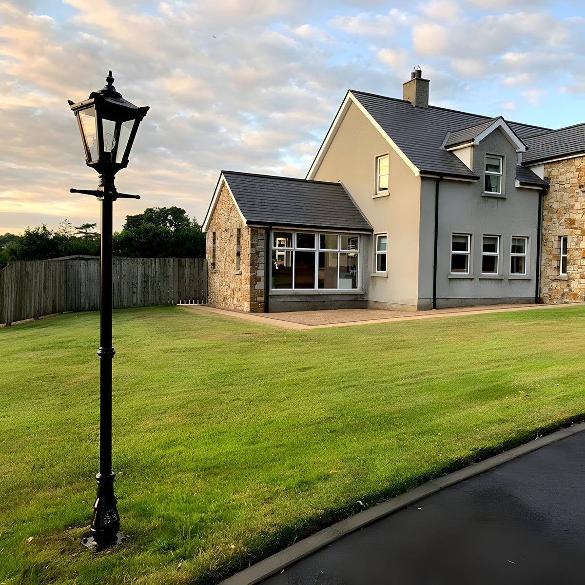 Victorian Cast Iron Lamp Post 2.6m in black with a four-sided lantern head, stepped crown and cast finial, shown on a lawn beside a house driveway.