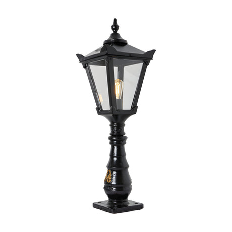 Large black Victorian cast iron pedestal post light with tapered four-sided lantern head, clear glass panels, stepped crown and cast finial atop an ornate column.