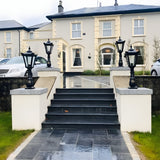 Large Victorian Cast Iron Pedestal Post Lights in black mounted on stone pillars beside steps at a house entrance, showing traditional tapered lantern heads.