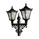 Black Victorian cast iron double-headed lamp post with two tapered four-sided lantern heads, clear glass panels, scrolled brackets and a central finial.