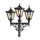 Victorian cast iron triple-headed lamp post in black with three tapered lantern heads, stepped crowns, cast finials and scrolled cross arm, shown against a plain white background.