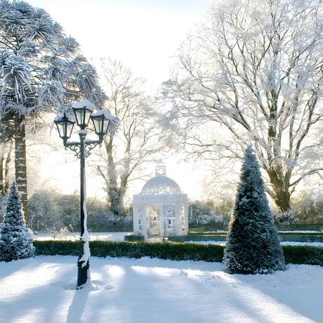 Victorian cast iron triple-headed lamp post in black, 3.5m tall with tapered lantern heads, shown snow-covered in a garden setting beside a domed pavilion.