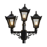 Victorian cast iron triple-headed lamp post in black, featuring three tapered lantern heads with glass panels, stepped crowns, cast finials and scrolled arm brackets on a plain white background.